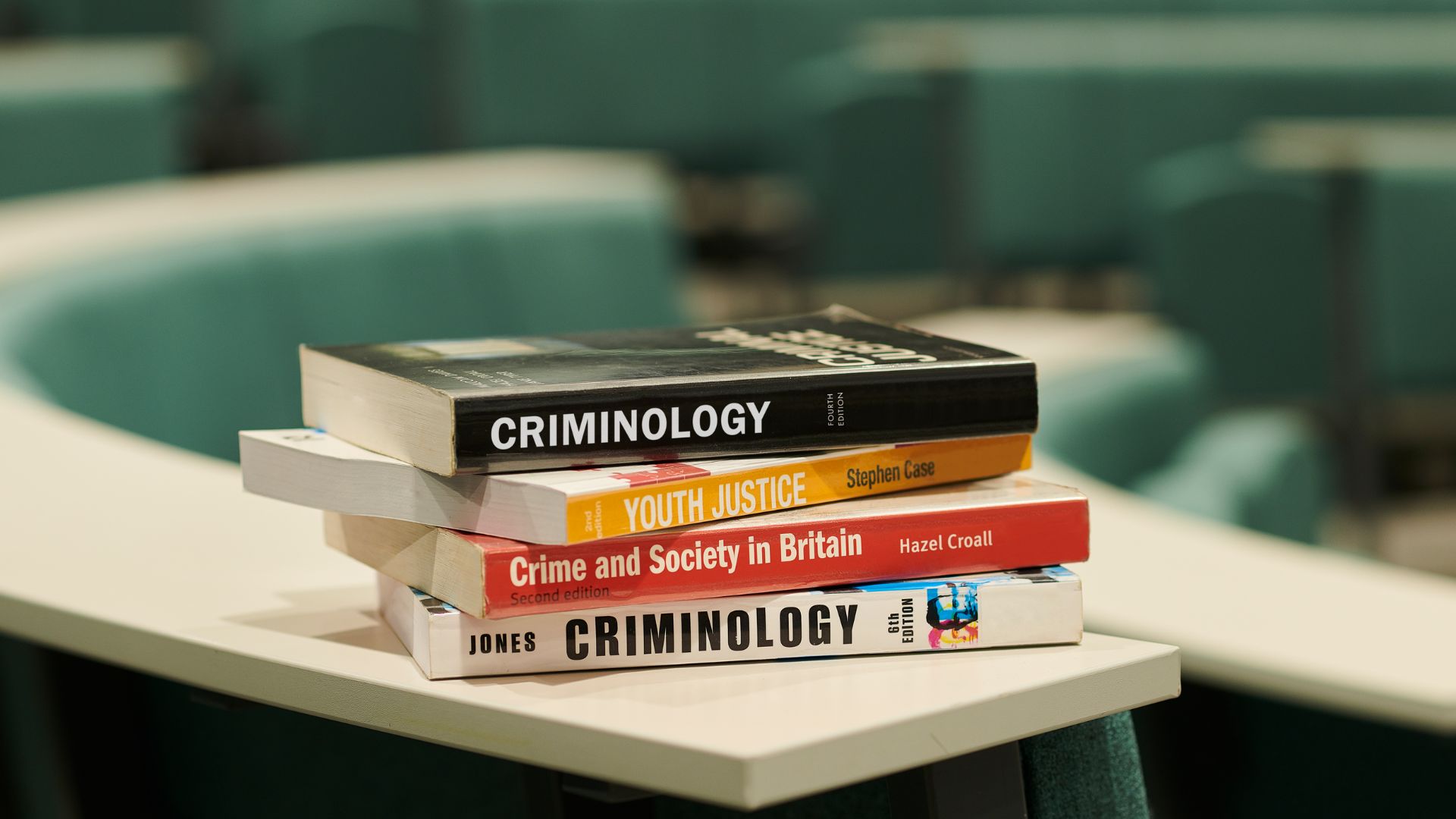 stack of criminology related books on a table