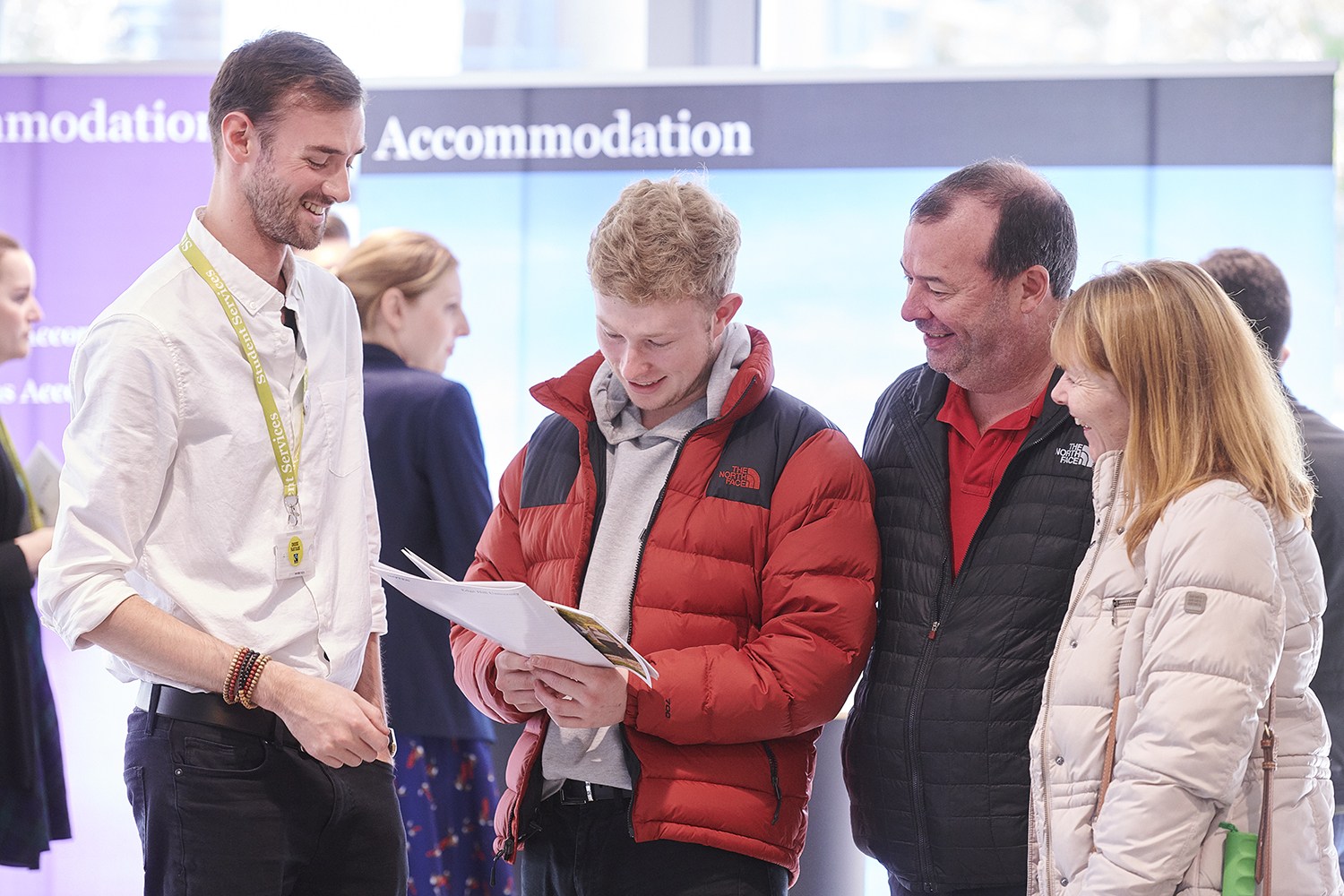 A prospective student and his parents receive accommodatio advice at an open day.