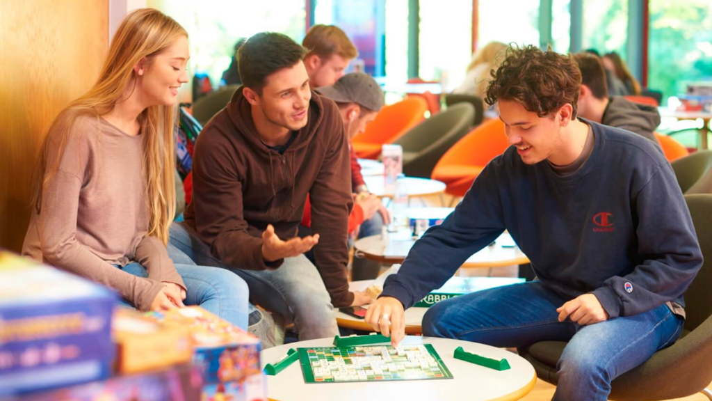 Three students playing Scrabble