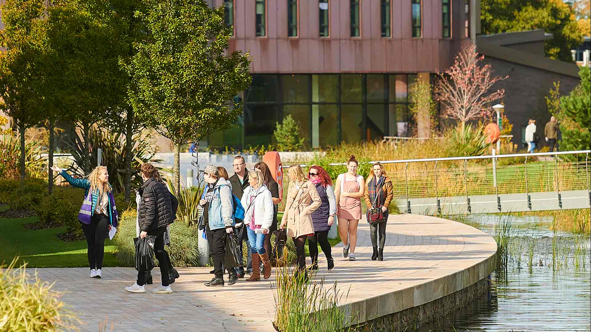 Prospective students receiving a tour walking around one of the many lakes