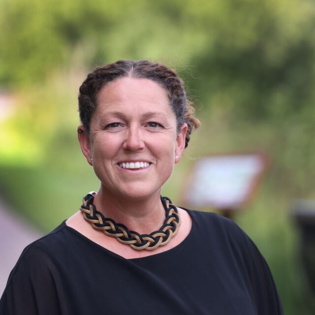 An image of Lucy Bray, Professor of Child Health Literacy, smiling at the camera against a green backdrop.