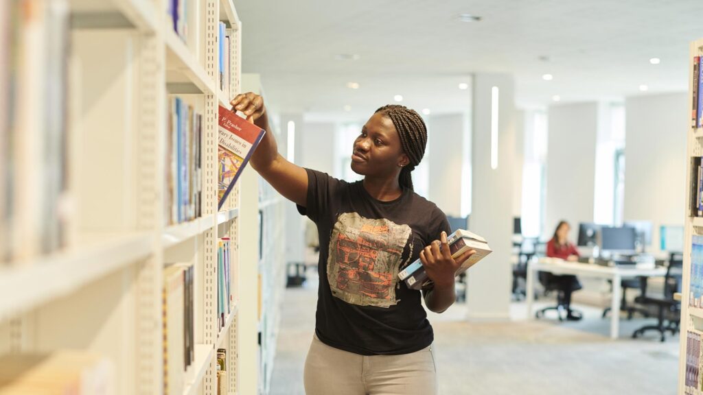 A student searching for books in the Catalyst building