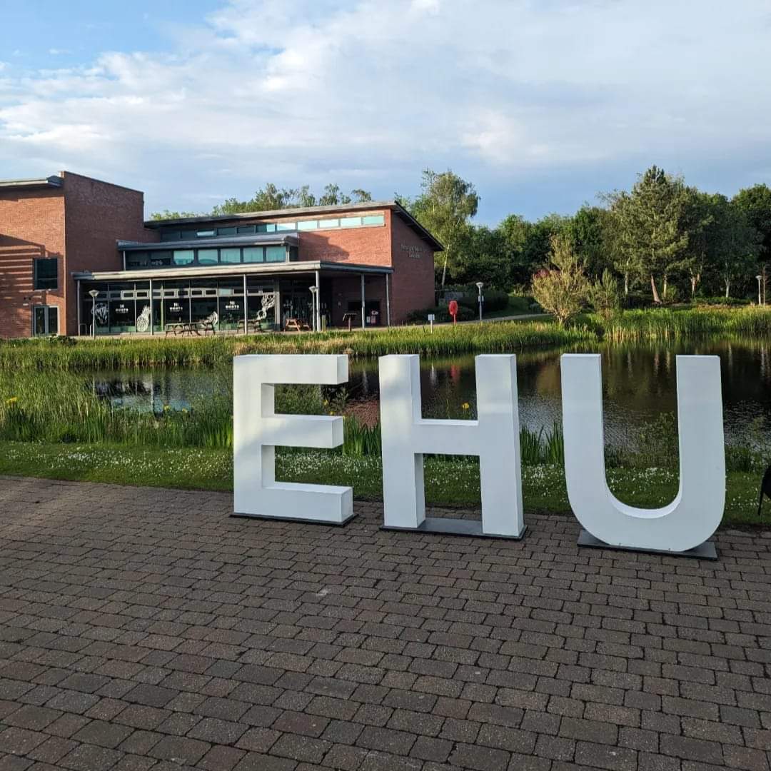 White 'EHU' 3D letters in front of the Faculty of Education Lake.