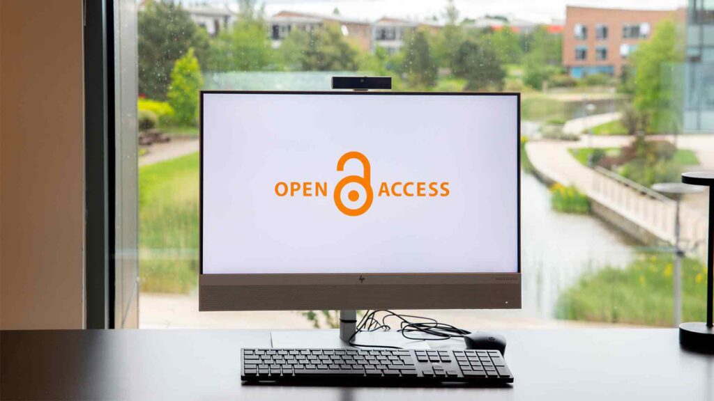 Image of a PC in the Edge Hill Catalyst building displaying the Open Access logo on its screen.