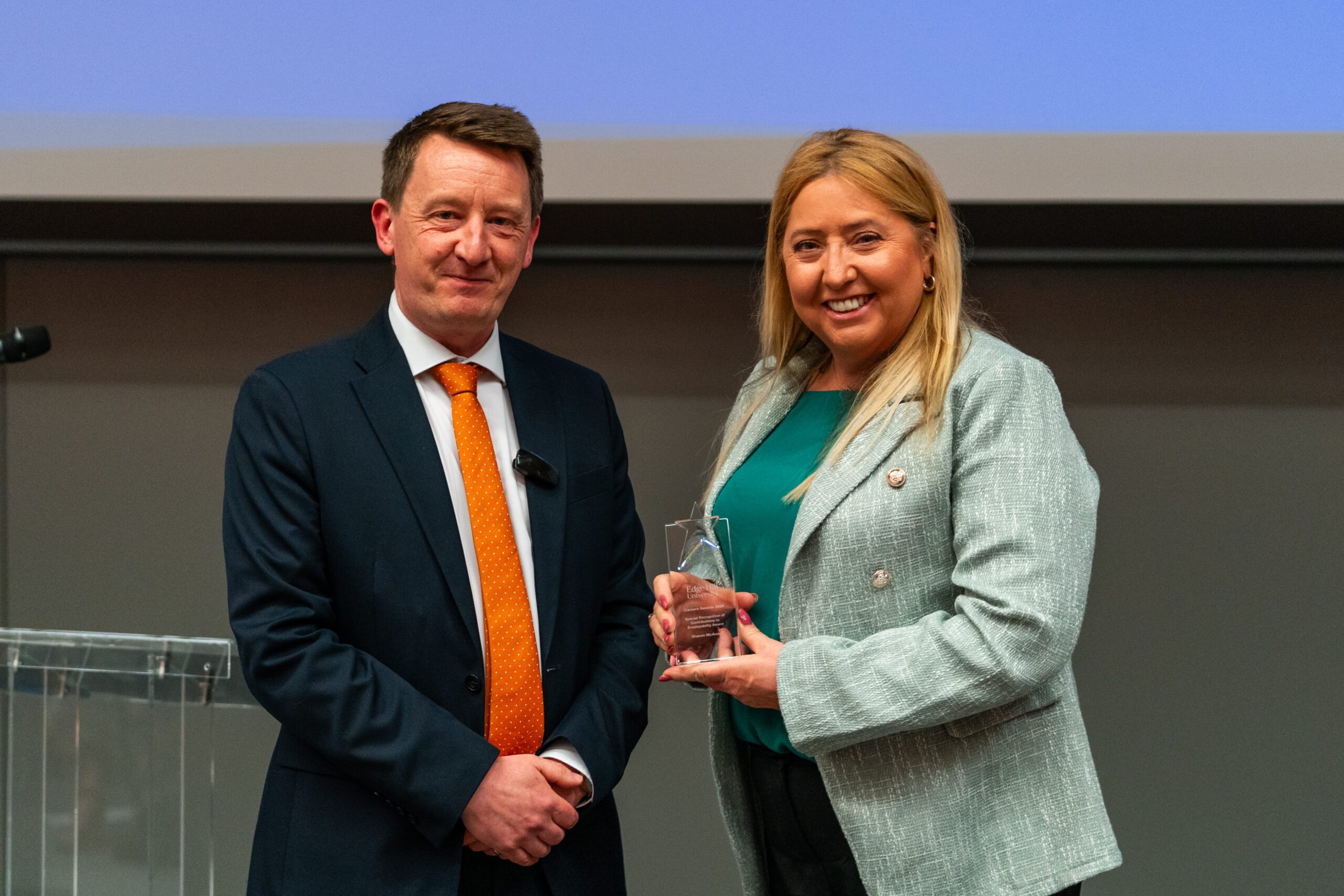 Senior Lecturer Sharon McAvoy with her glass award, photographed with Pro Vice-Chancellor, Liam Owens.