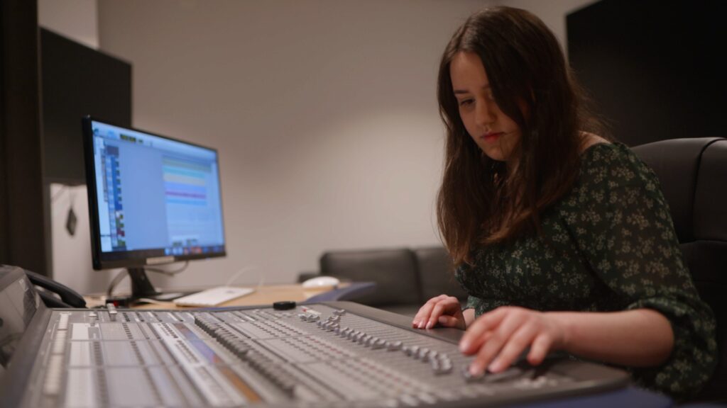 Emily sat at a mixing desk