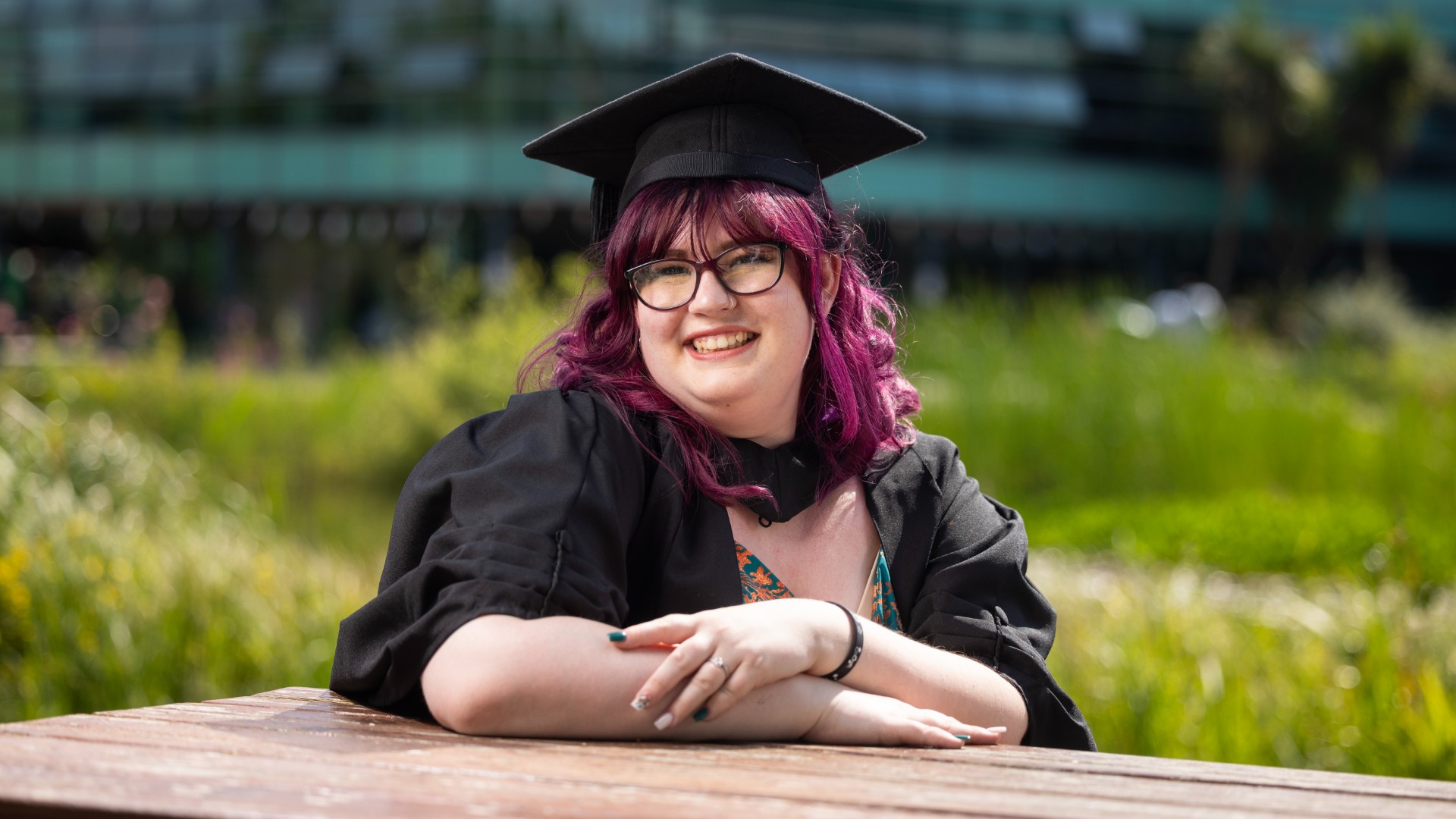 Kate smiling at the camera wearing her cap and gown