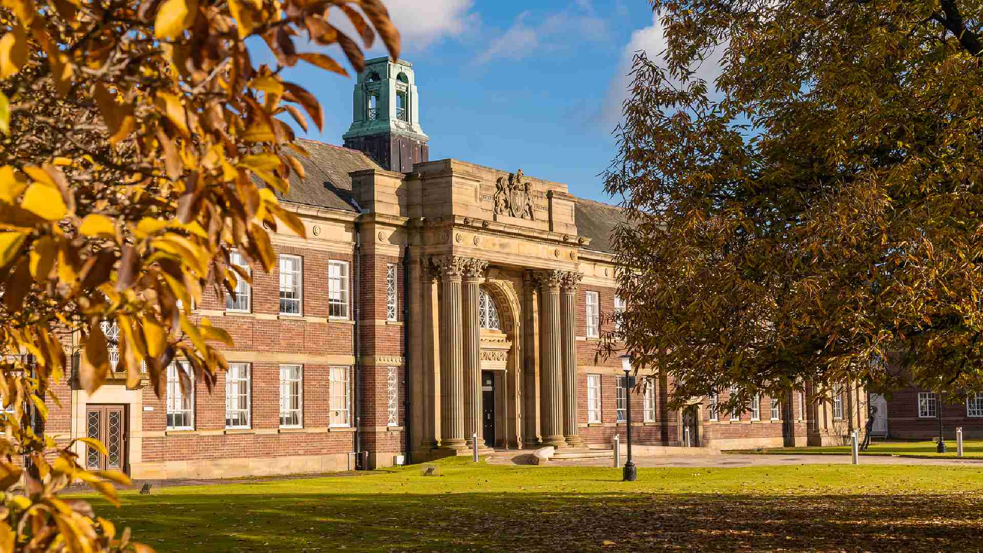 An outside image of the Main Building on campus during the autumn season