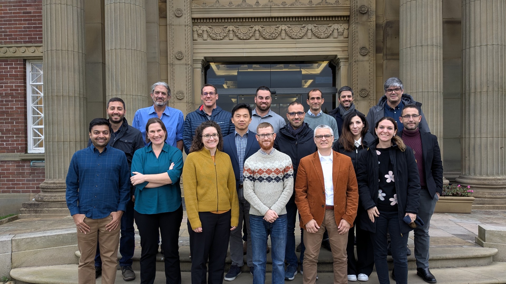 NASA and ESA colleagues gathered smiling in front of Edge Hill’s historic Main Building.